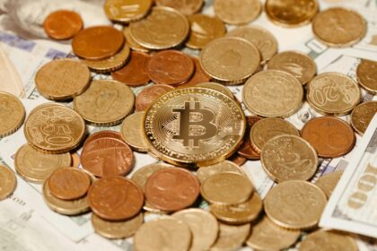 A top-down photo of assorted coins arranged on a table, symbolizing diverse funding and investment in Bitcoin startups amid a broader crypto VC slowdown.