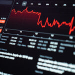 Red downward financial chart on a digital screen, symbolizing market volatility due to tariffs and halted Bitcoin investment.